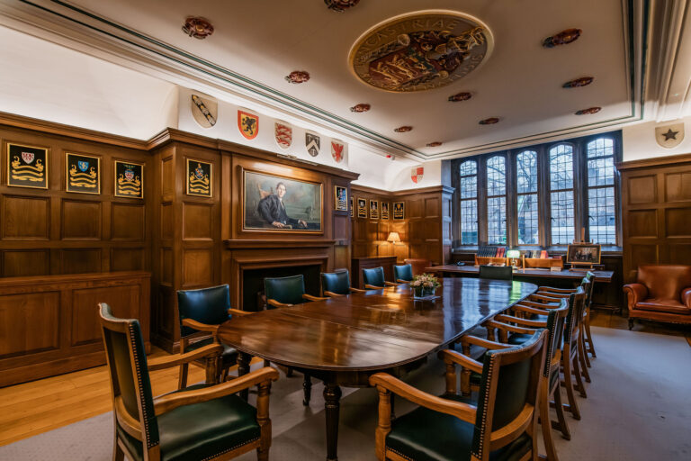 An oak-panelled room with painted coats of arms, a polished table, green leather chairs and a moulded ceiling, Gray's Inn