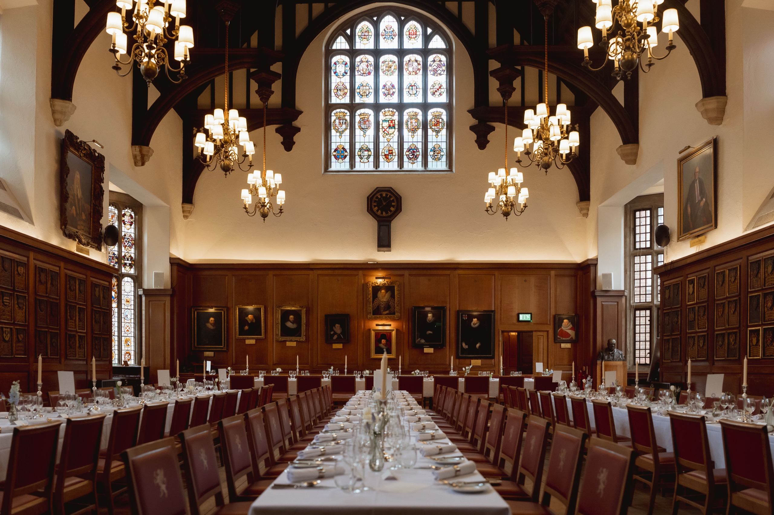 The Hall set for a wedding breakfast, with long white tables, red chairs and candles, Gray's Inn