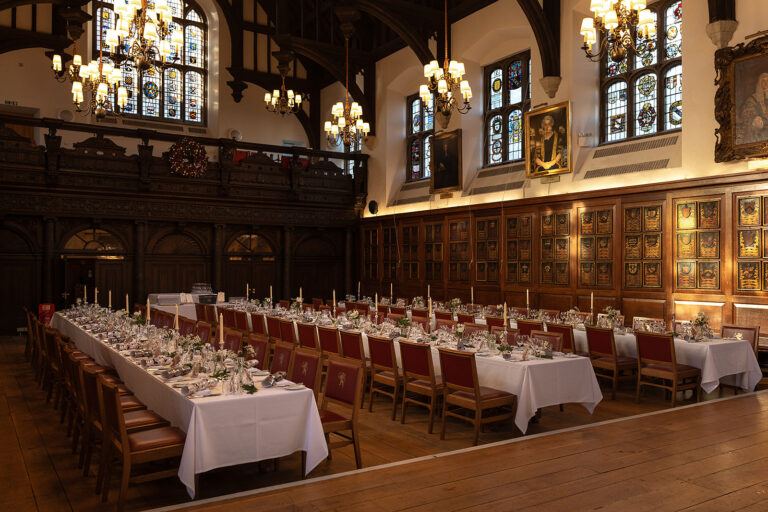 Long dressed tables in the Hall, with the carved wooden screen and gallery at the end, Gray's Inn