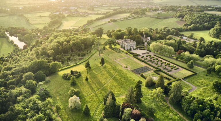 An aerial view of the estate in early summer, with the River Thames curving through the trees on the left, Hedsor House