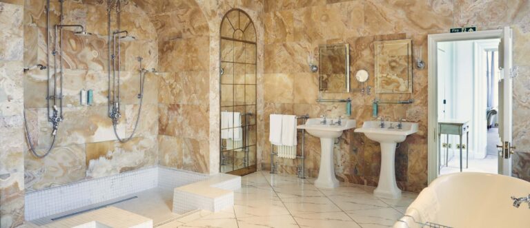 The honey-coloured onyx bathroom with twin basins and a rain shower, Hedsor House