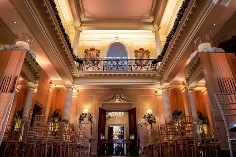 Centre Hall lit for an evening ceremony, with rows of chairs facing the doors and candles on the columns, Hedsor House