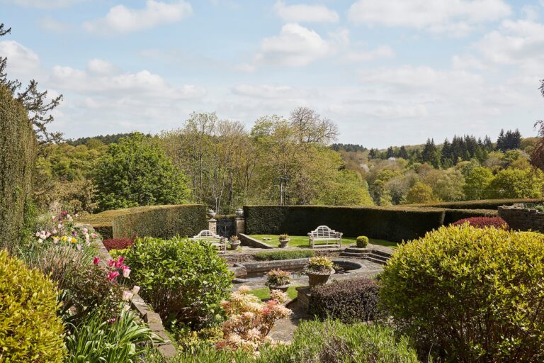 The Dutch Sunken Garden with its stone benches and pond, and the wooded hills beyond, Hedsor House