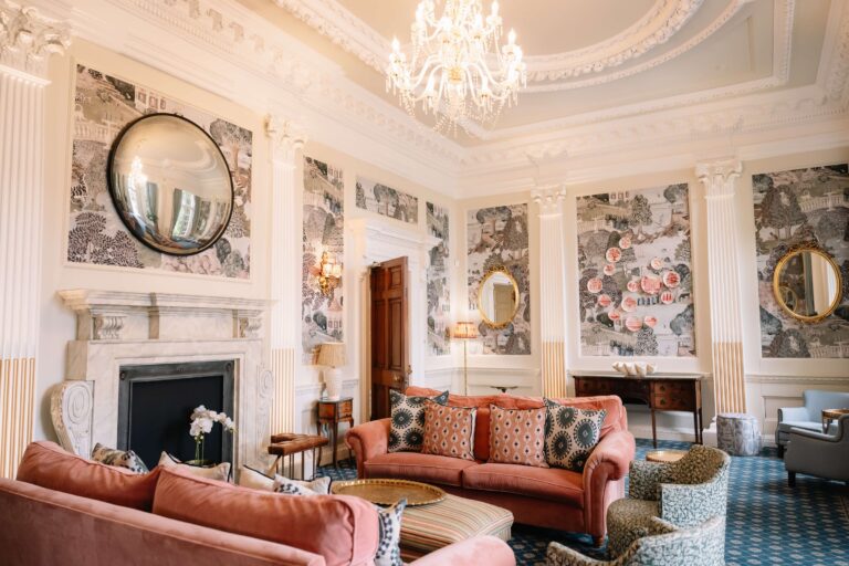 The Drawing Room, with a marble fireplace, a convex mirror and pink sofas, used for drinks after the ceremony, Hedsor House