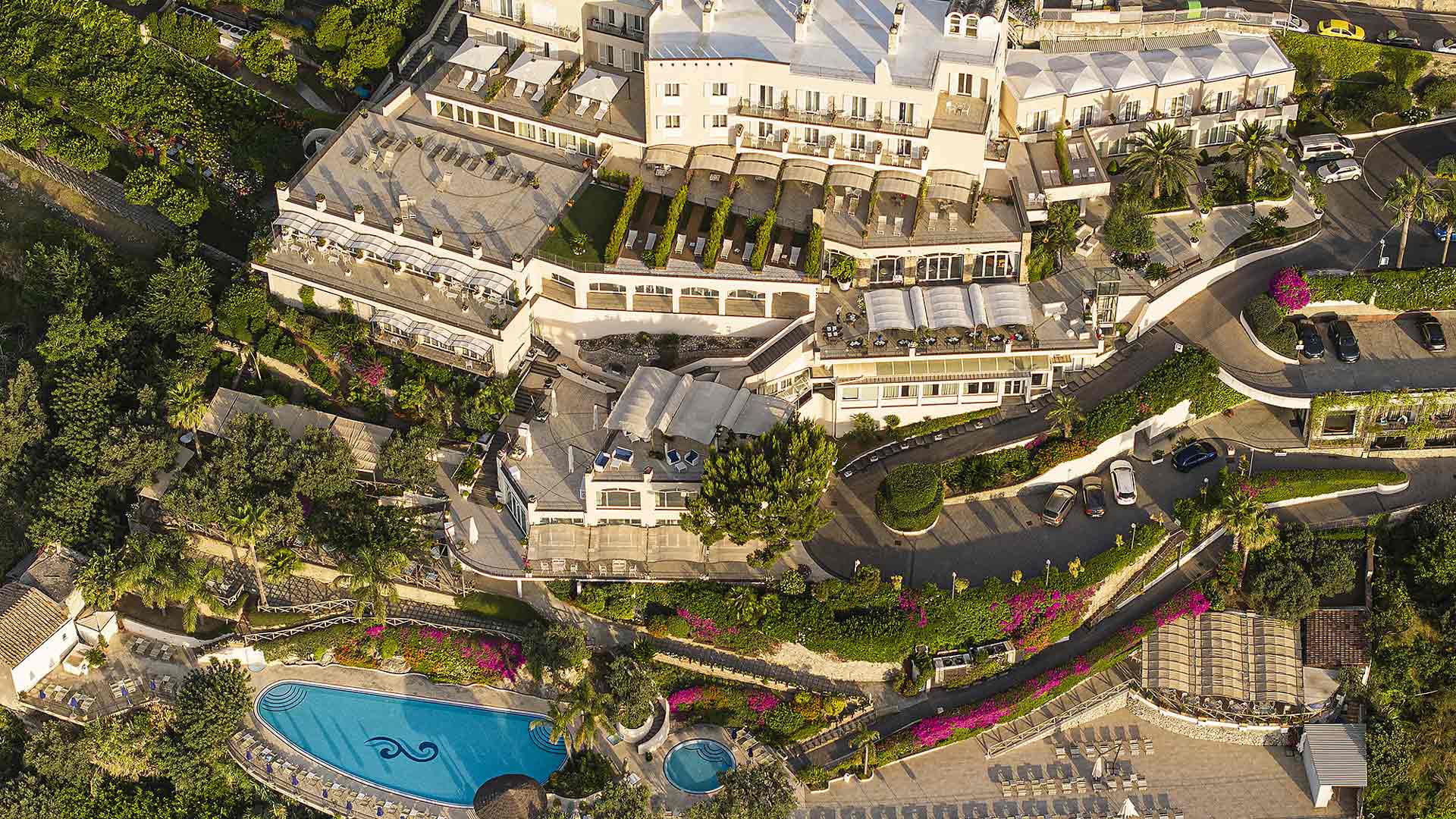 Aerial view of the hotel's terraced gardens, pool and buildings on the hillside, Hotel Raito