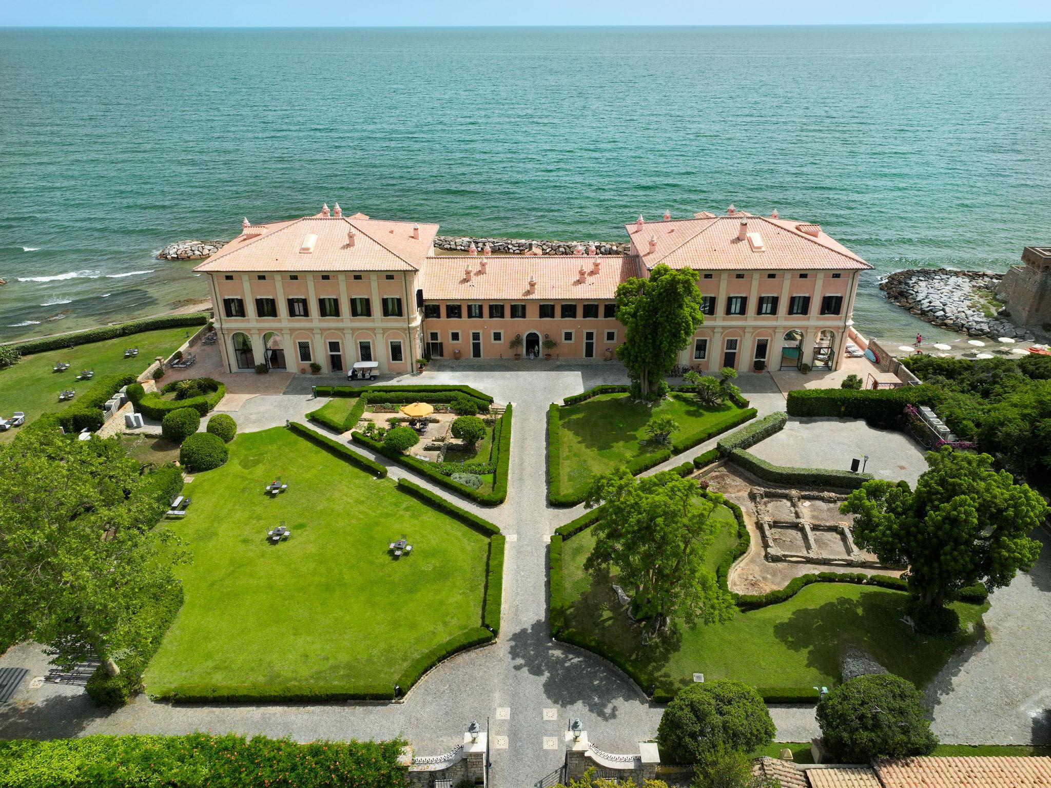 The villa from the air, with its formal gardens on the land side and the Tyrrhenian Sea beyond, La Posta Vecchia Hotel