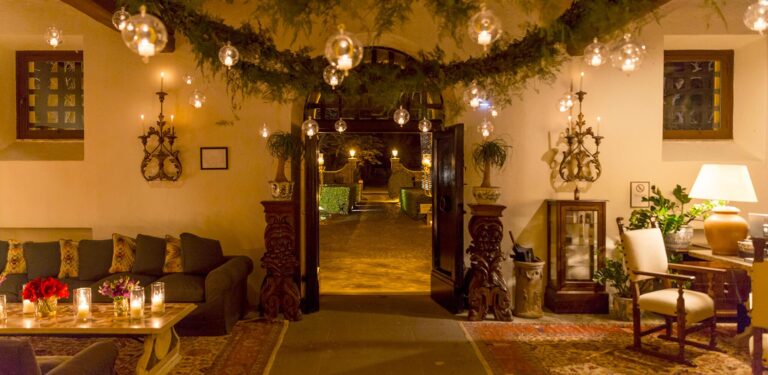 A salon dressed with garlands and candles for an evening event, La Posta Vecchia Hotel