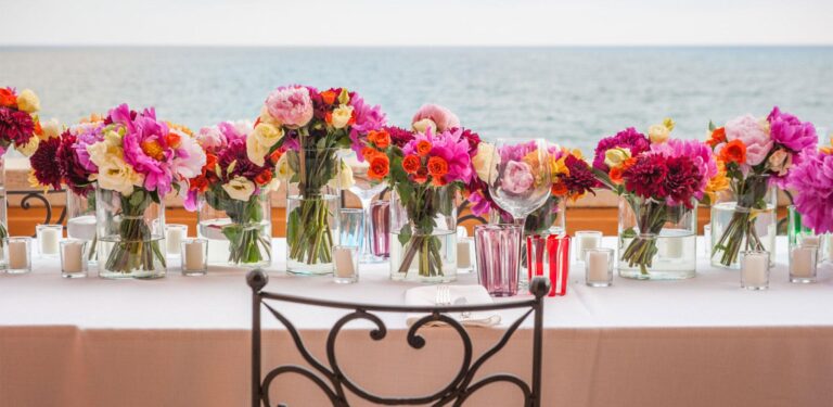 Mixed flowers along a table set on the terrace above the sea, La Posta Vecchia Hotel