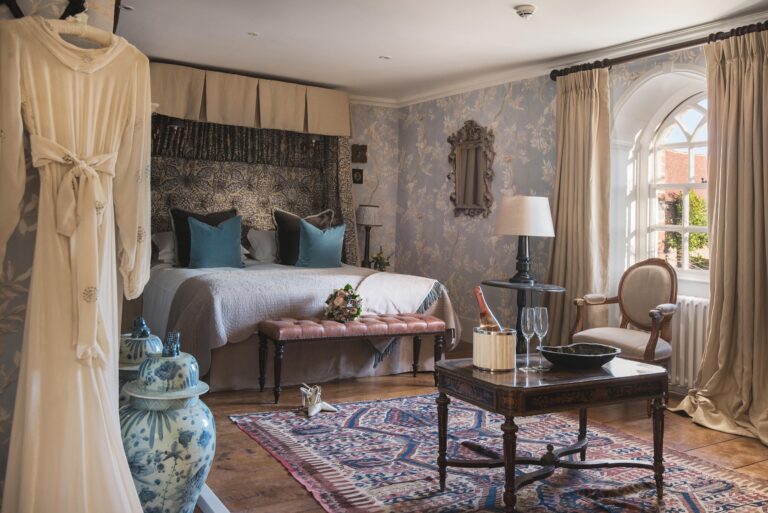 The Wisteria Bedroom at Battel Hall, dressed as a bridal suite with a canopied bed and hand-painted wallpaper, Leeds Castle