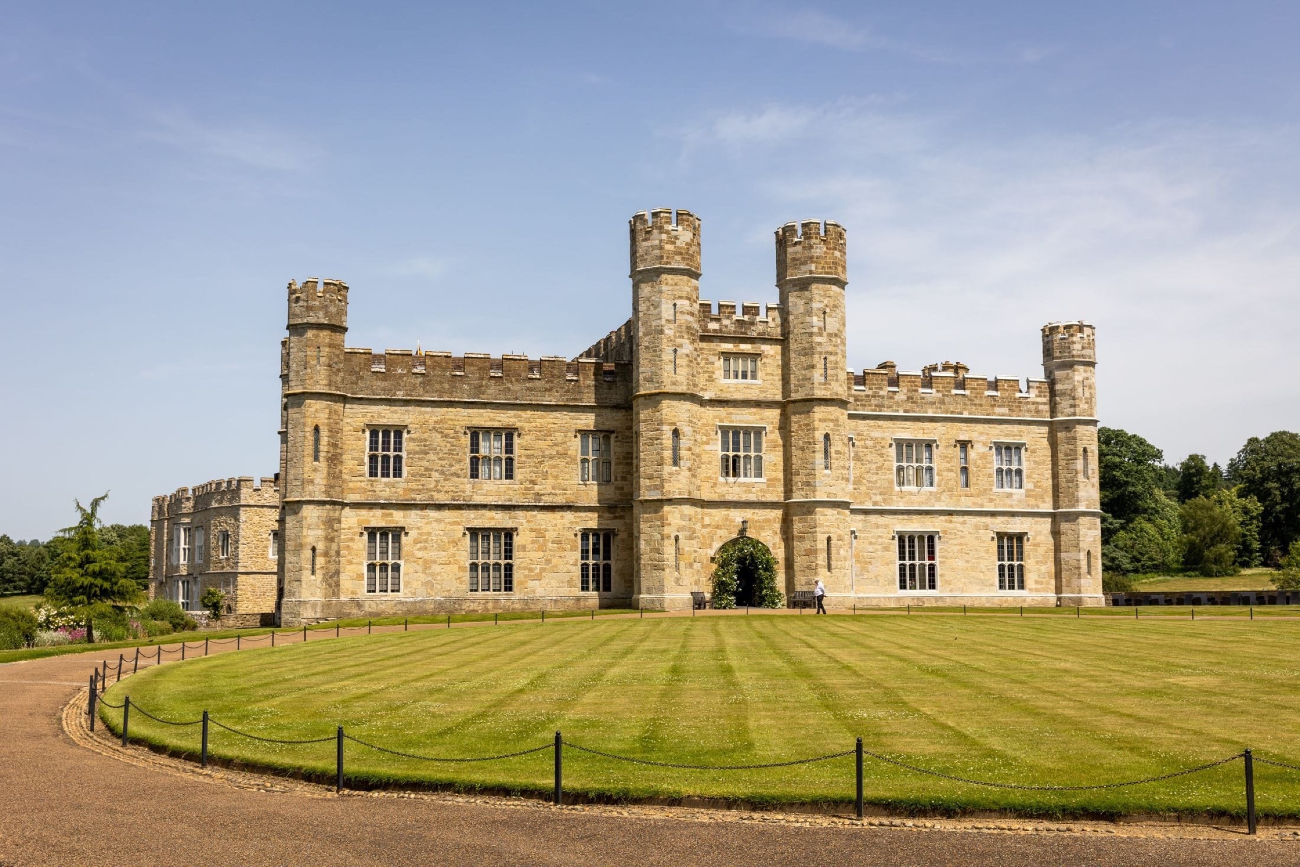 The New Castle seen across the striped front lawn, with its crenellated towers and ivy-framed door, Leeds Castle
