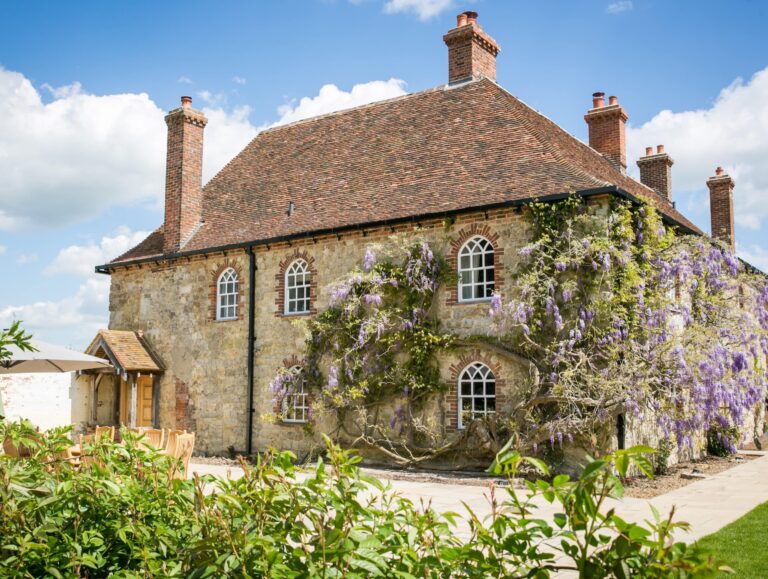 Battel Hall, the medieval manor house, with wisteria in flower across its stone walls, Leeds Castle