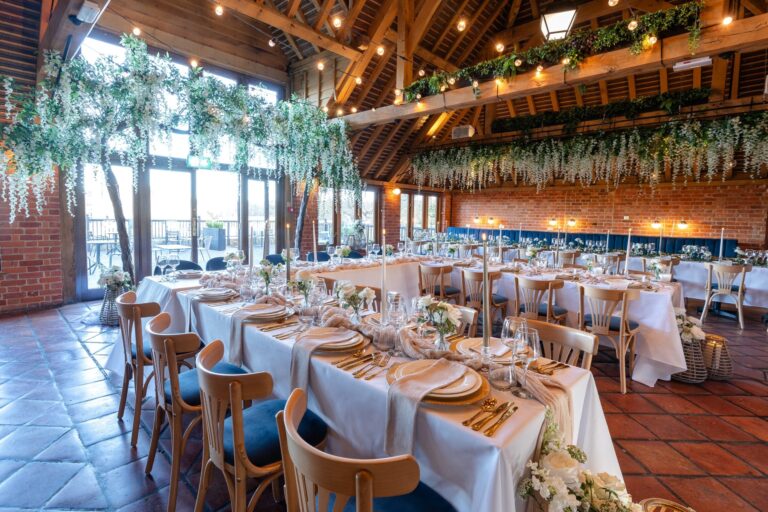 The Fairfax Barn with tables laid for dinner, trailing white wisteria and glass doors onto the terrace, Leeds Castle