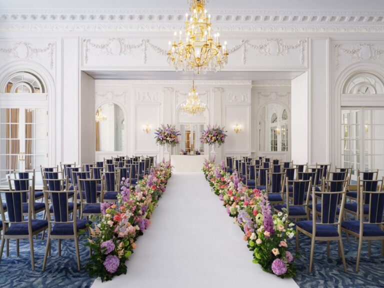 A white panelled room laid out for a ceremony, with a white aisle lined with flowers between rows of chairs, Mandarin Oriental Hyde Park
