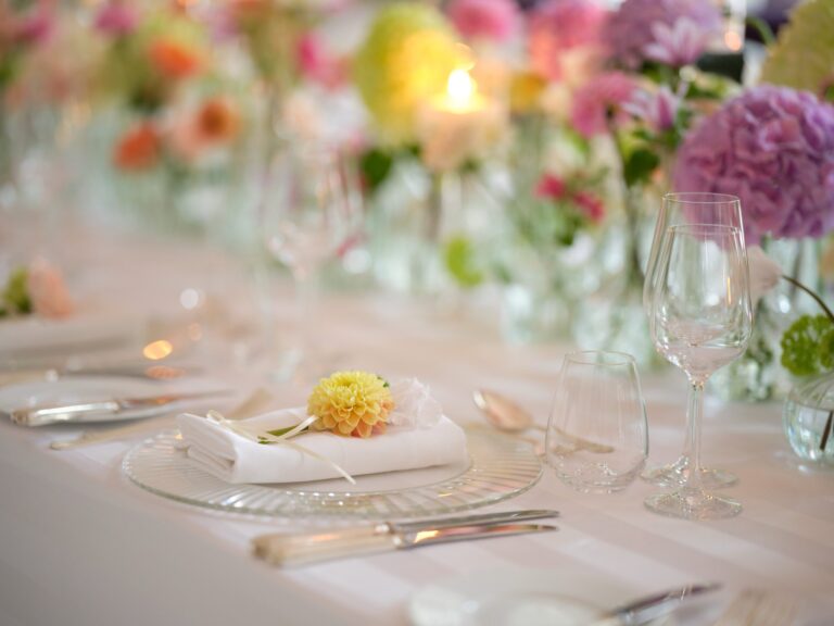 A close view of a wedding place setting with glassware, candles and pastel flowers, Mandarin Oriental Hyde Park