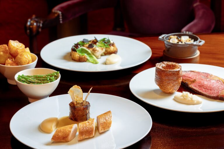 A spread of plated dishes on a dark wooden table, Mandarin Oriental Hyde Park