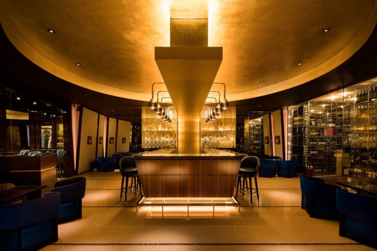 The Mandarin Bar, a curved room in warm gold light with a central bar counter, Mandarin Oriental Hyde Park