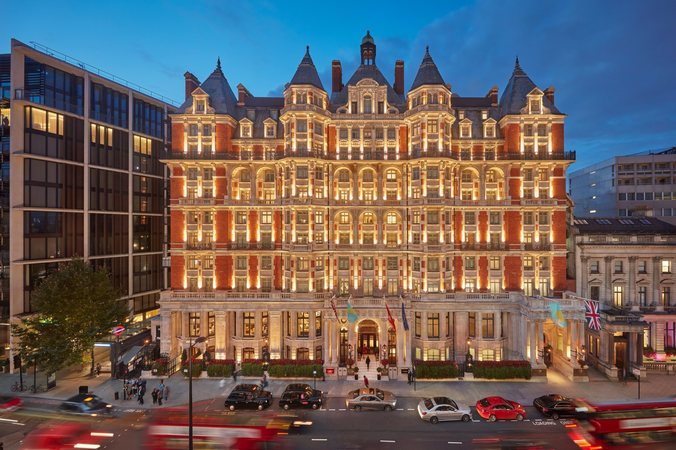 The red-brick and stone Knightsbridge facade at dusk, with its turrets lit and traffic on the street below, Mandarin Oriental Hyde Park