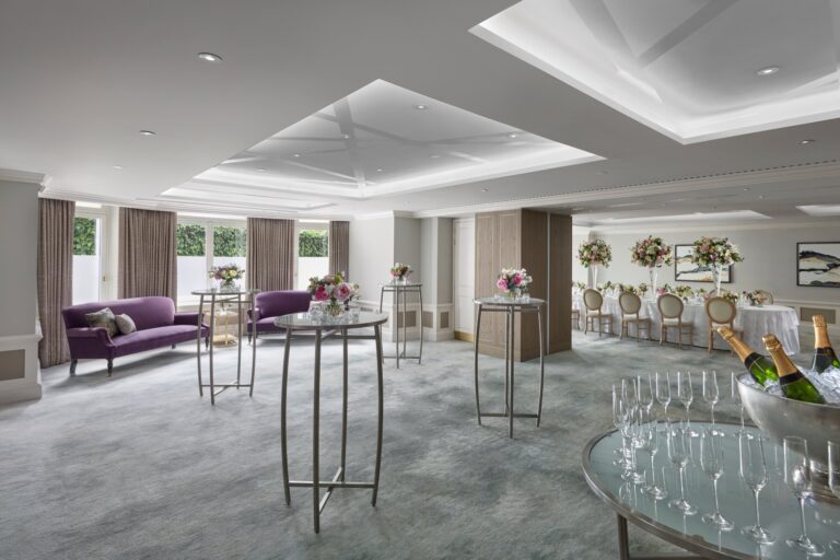 A daylit function room set for a standing reception with high tables, sofas and flowers, Mandarin Oriental Hyde Park