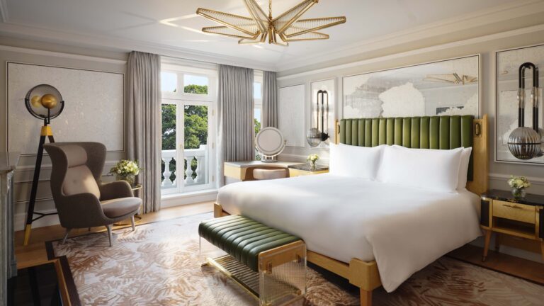 A suite bedroom with a green headboard, pale walls and French windows onto a balcony, Mandarin Oriental Hyde Park