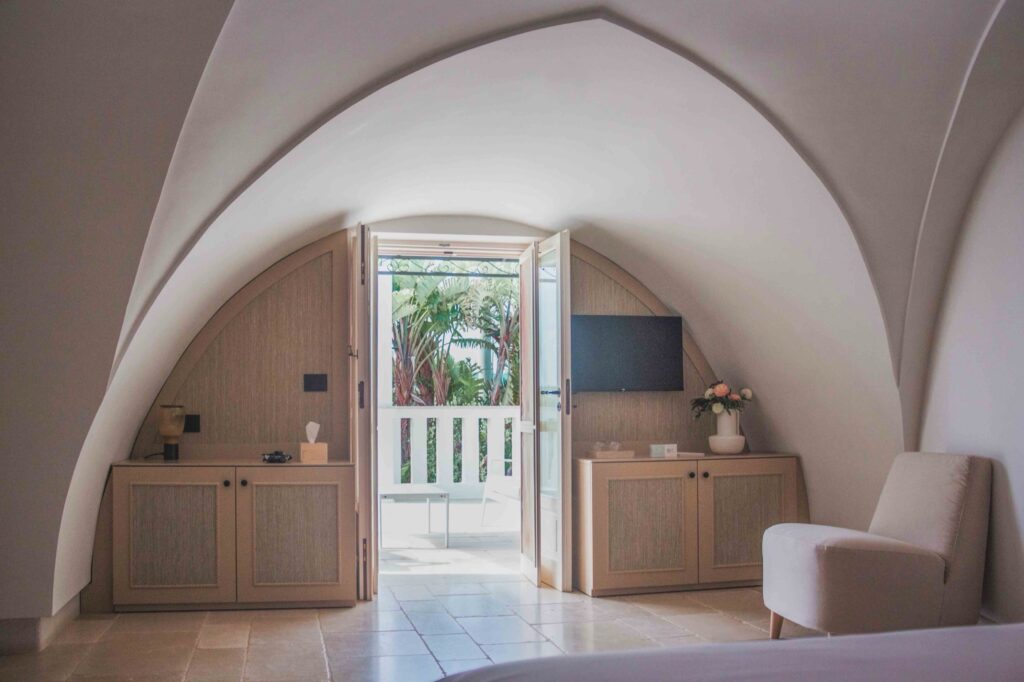 A vaulted Superior Attic Double Room with its door open to the terrace, Masseria Don Luigi