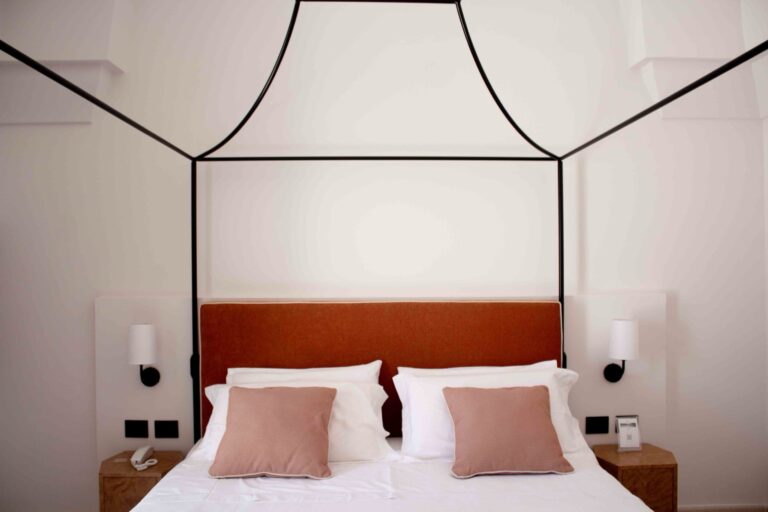 A Superior room with an iron canopy bed under a vaulted ceiling, Masseria Don Luigi