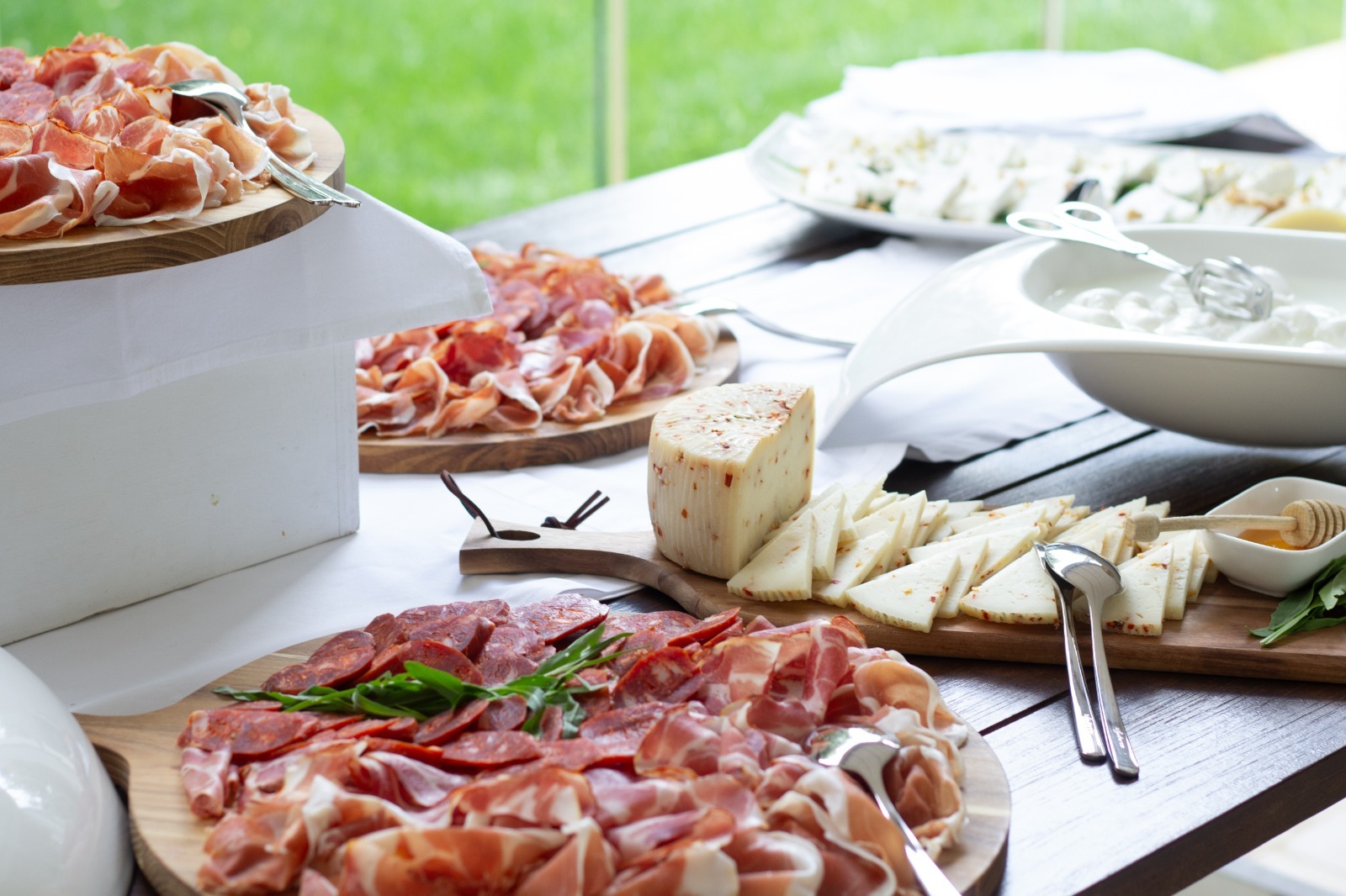 Cured meats and local cheeses set out on a buffet table outdoors, Masseria Don Luigi