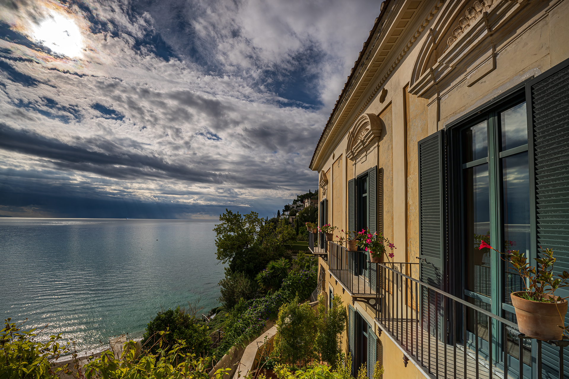 Palazzo Suriano facade with green-shuttered balconies above the sea at Vietri sul Mare, under a dramatic sky, Palazzo Suriano