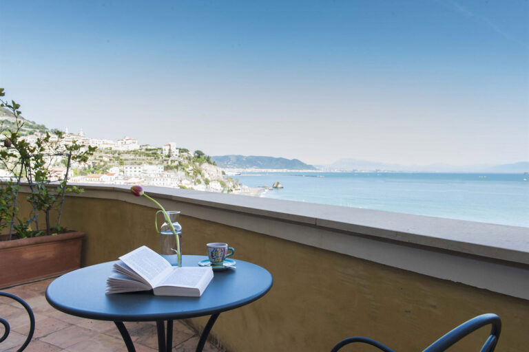 Balcony table with a book and coffee overlooking Vietri sul Mare and the Gulf of Salerno, Palazzo Suriano