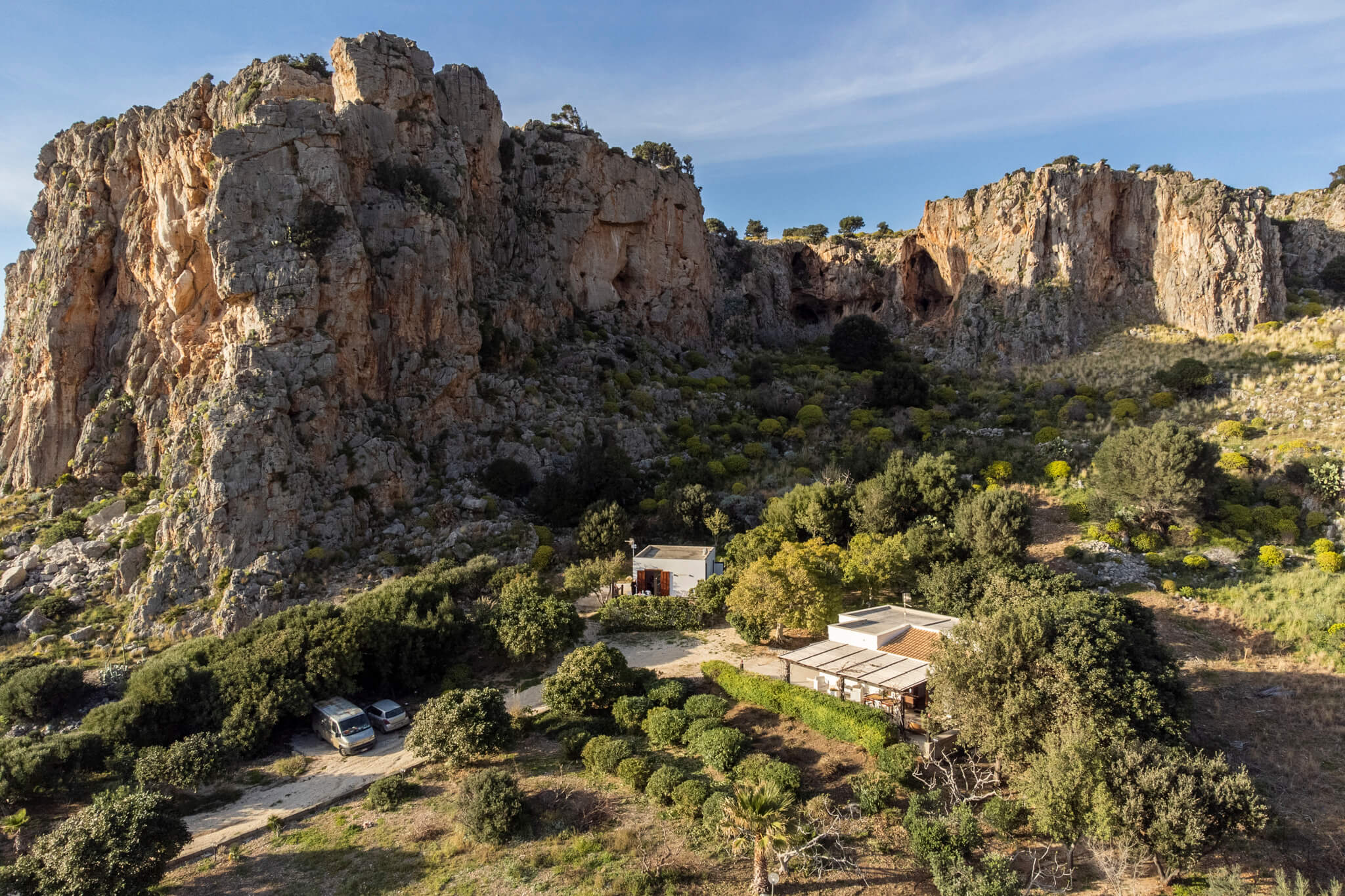 Closer aerial view of the cottages, garden and parking beneath the cliff face, Pittalumari Makari