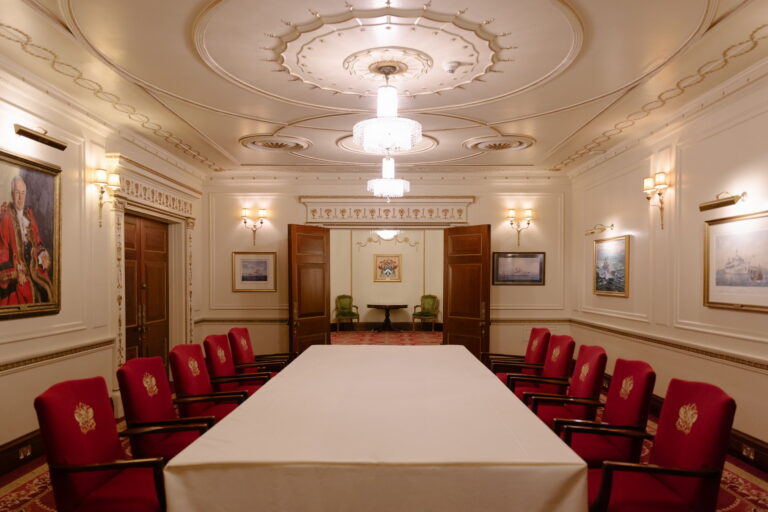 The Humber Room set boardroom style, with red chairs around a long table and a plasterwork ceiling rose, Plaisterers' Hall