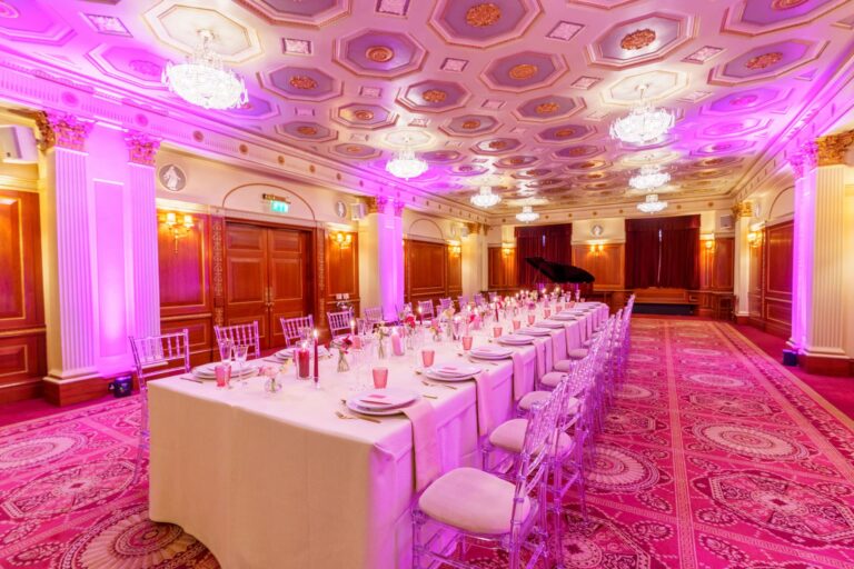 Long banqueting tables in the Great Hall washed with magenta lighting, Plaisterers' Hall