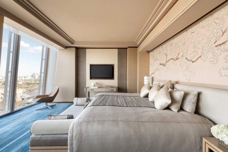 A bedroom in the Westminster Suite with a painted blossom wall and windows to the river, Shangri-La The Shard, London