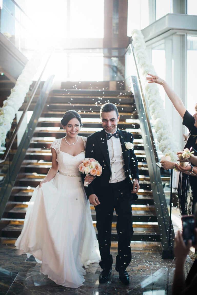 A newly married couple walking down the grand staircase through confetti, Shangri-La The Shard, London