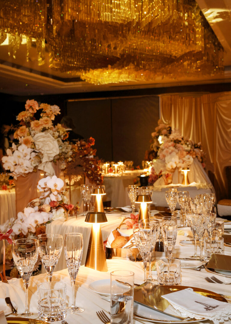 A wedding table with crystal glasses, gold lamps and arrangements of blush roses and orchids, Shangri-La The Shard, London