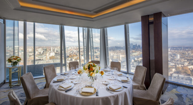 A round table laid for lunch in a corner space with windows on two sides over the city, Shangri-La The Shard, London