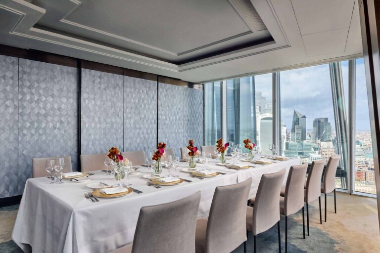 A long table laid for dinner beside windows facing the towers of the City of London, Shangri-La The Shard, London