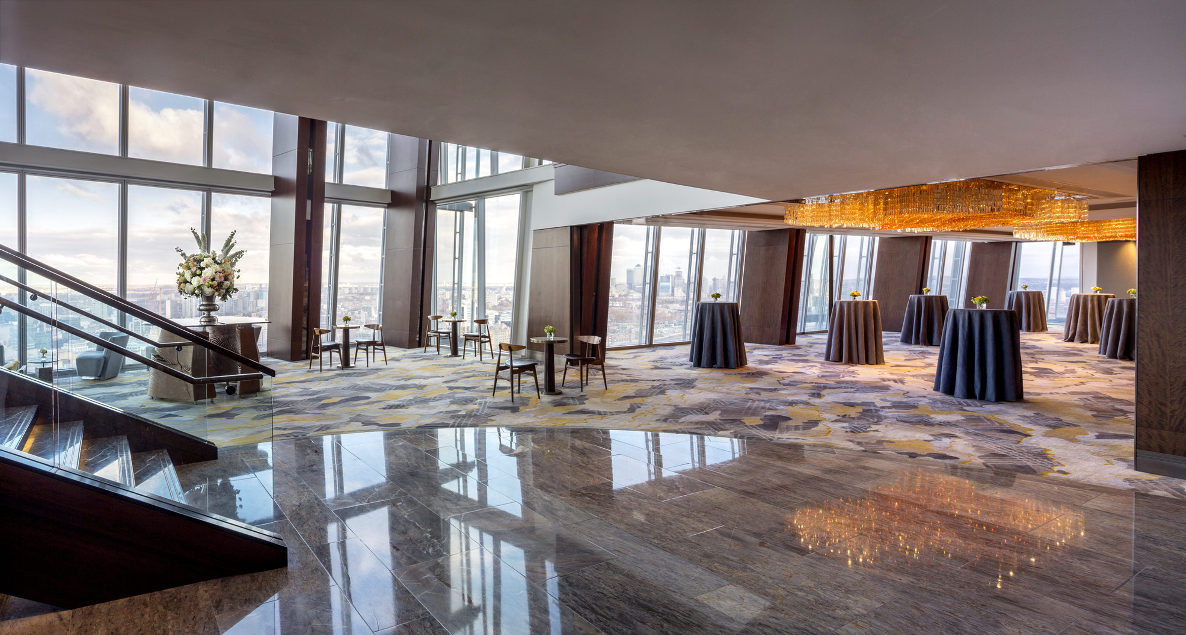 The level 34 foyer with its polished marble floor, the foot of the grand staircase and cocktail tables by the windows, Shangri-La The Shard, London