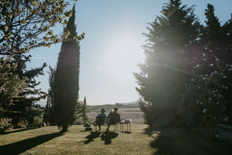Two guests seated on a lawn between cypresses, looking out over the countryside, Susafa