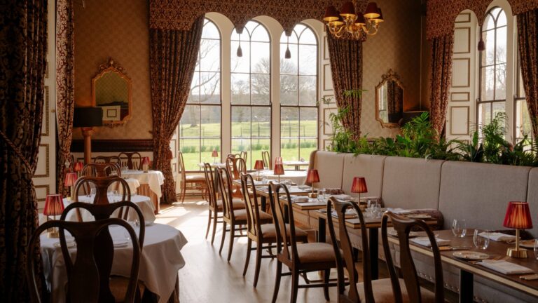 Samuel's Restaurant, with arched windows over the parkland and tables laid with white cloths, Swinton Park