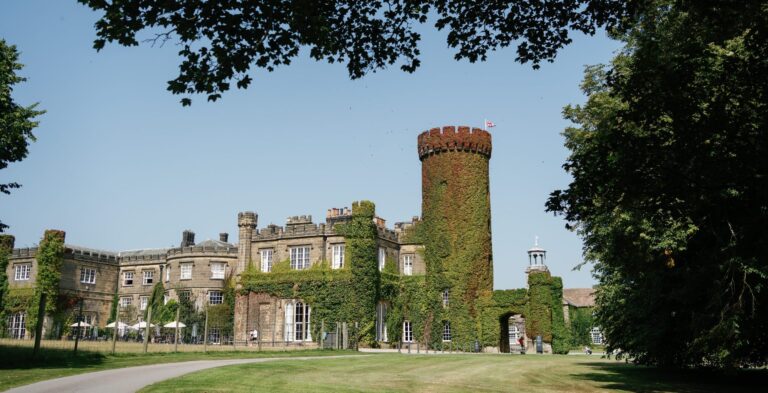 The castellated east front and round tower from the lawn in summer, Swinton Park