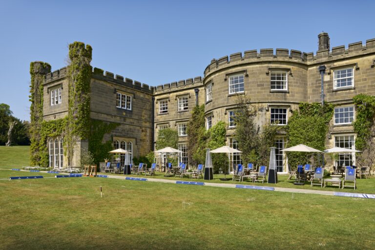 Parasols and deckchairs on the lawn beside the castle, laid out for the Pommery Champagne and Croquet Lawn, Swinton Park