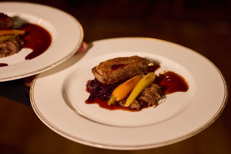 A plated main course of braised meat with glazed carrots and red cabbage, Swinton Park