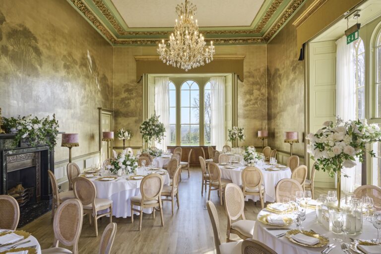 The Ballroom laid with round tables for a wedding breakfast under a crystal chandelier, Swinton Park