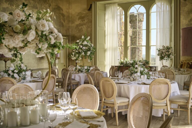 Round tables in the Ballroom dressed with white roses, candles and cane chairs, Swinton Park