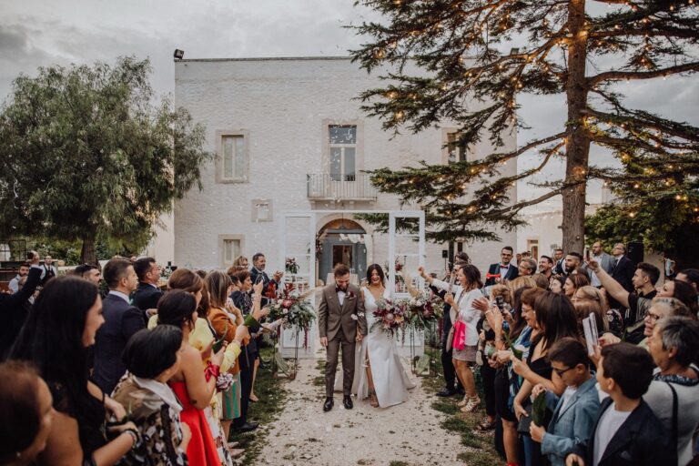 Guests line the path as a couple leave the ceremony in front of the masseria, Tenuta Pinto