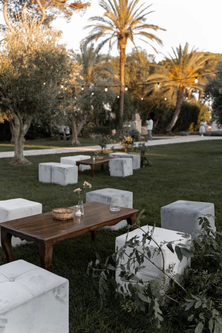 Low seating on the lawn under olive trees and palms, Tenuta Pinto