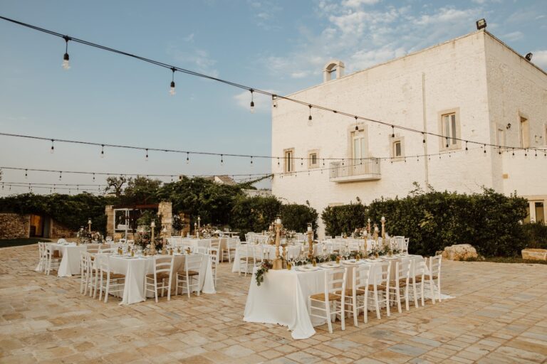 Tables laid on the stone-paved courtyard beside the masseria, Tenuta Pinto
