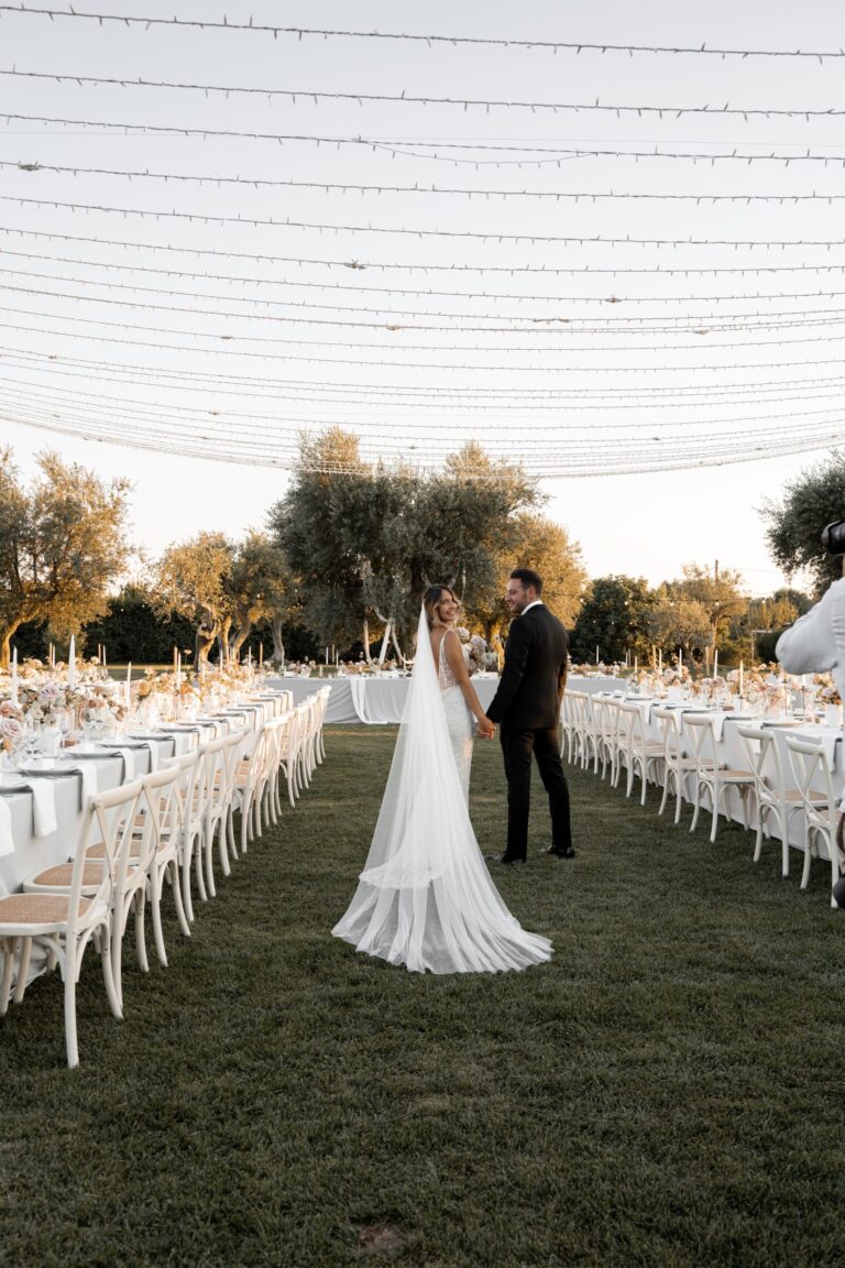 Long tables under strings of lights in the olive grove, Tenuta Pinto