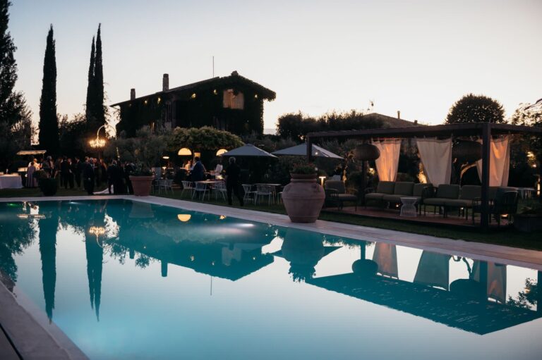 The pool at dusk reflecting the farmhouse and cypresses, Tenuta San Masseo