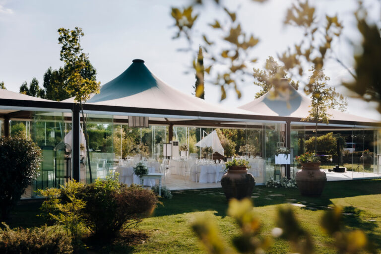The glass Vista Cube by day, laid for a reception, seen from the garden, Tenuta San Masseo